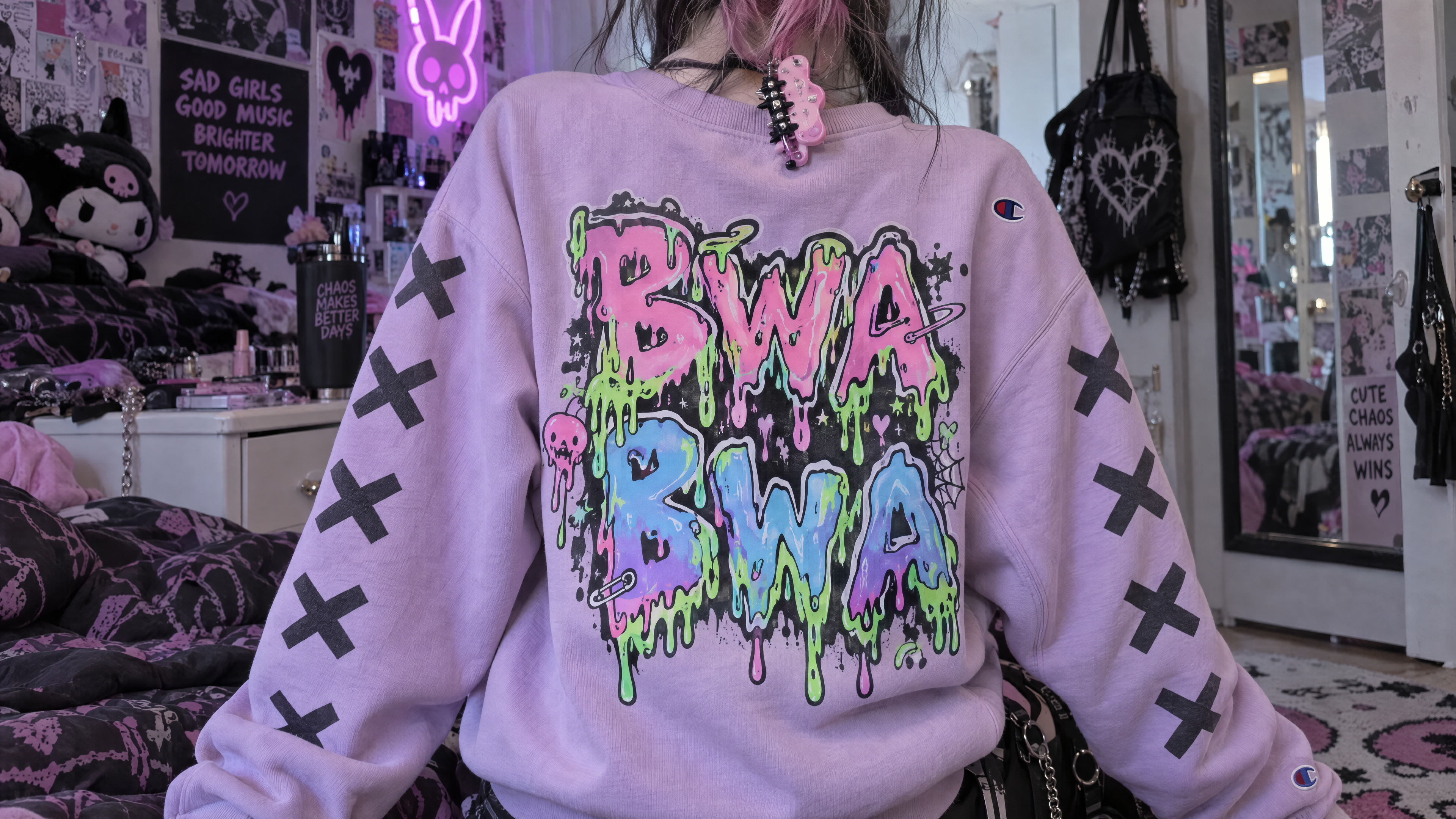 "A candid photograph of the back of a oversized pastel-colored Champion sweater being worn by someone, showcasing a pastel cyber goth aesthetic. The sweater is a soft pastel lavender or pink, with the